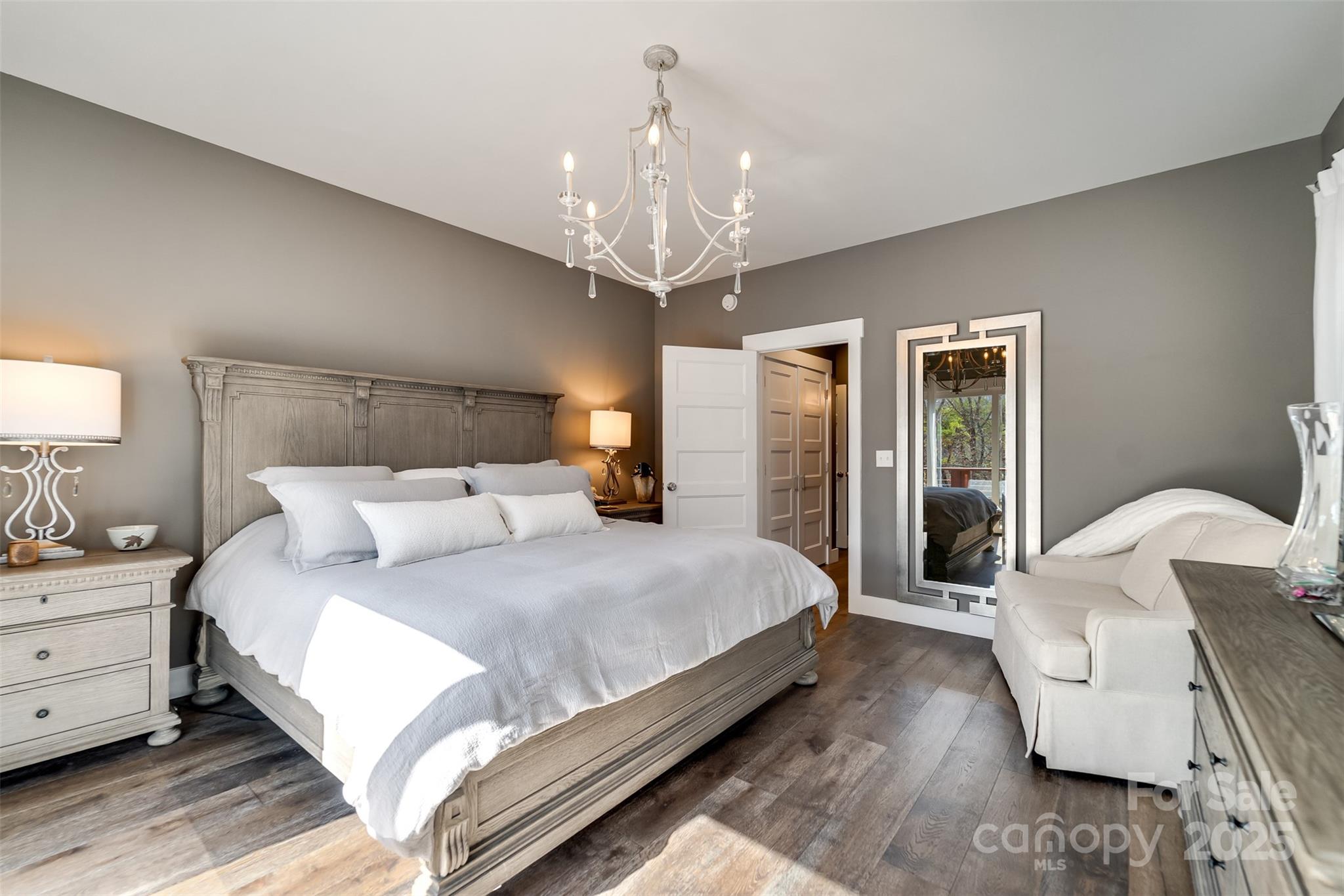 117 Amberleaf Way Cullowhee, NC 28723 - Photo 21 of 47 a spacious bedroom with a bed chandelier and a window