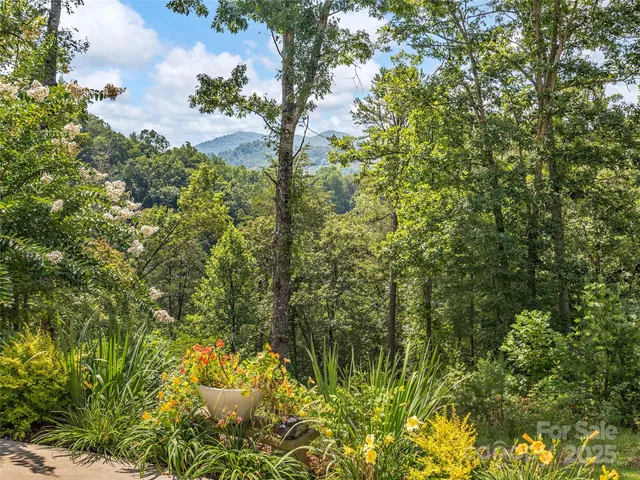 a kitchen with stainless steel appliances kitchen island granite countertop a refrigerator a oven a stove and a wooden floors