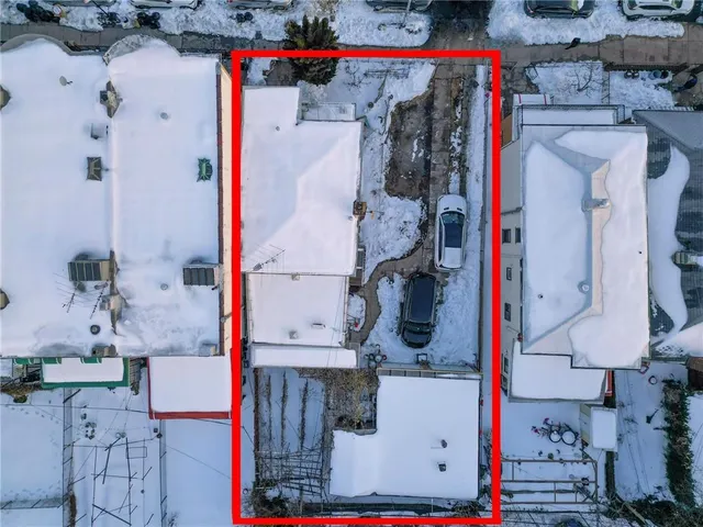 a utility room with a refrigerator and cabinets