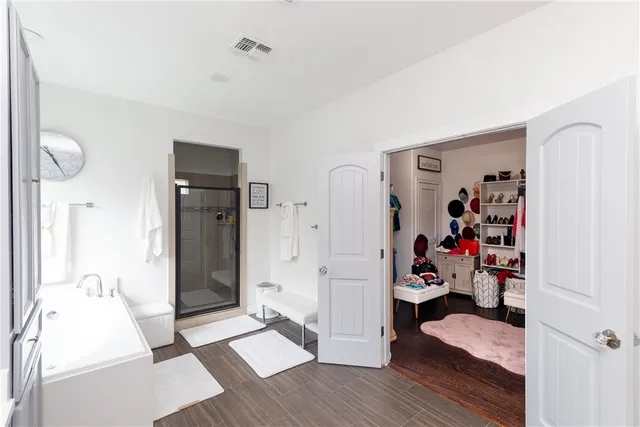 a view of a bedroom with walk in closet and wooden floor