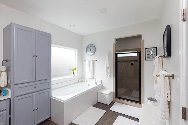 a bathroom with a tub sink shower and mirror