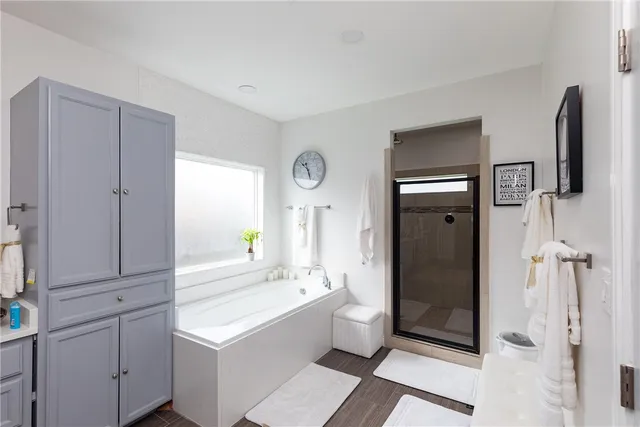 a bathroom with a tub sink shower and mirror