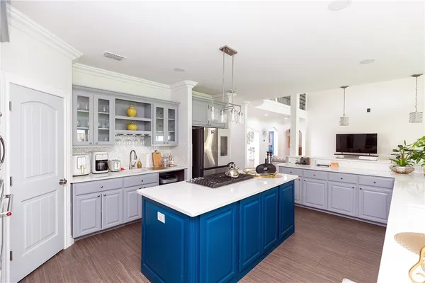 a kitchen with kitchen island a sink stove and refrigerator