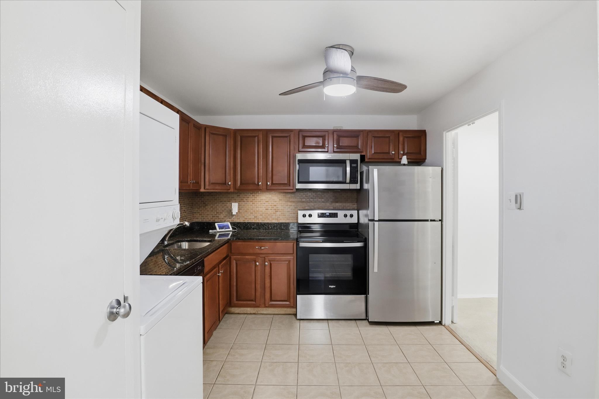 250 South Reynolds Street, Unit 105 Alexandria, VA 22304 - Photo 11 of 39 a kitchen with stainless steel appliances granite countertop a refrigerator and a stove