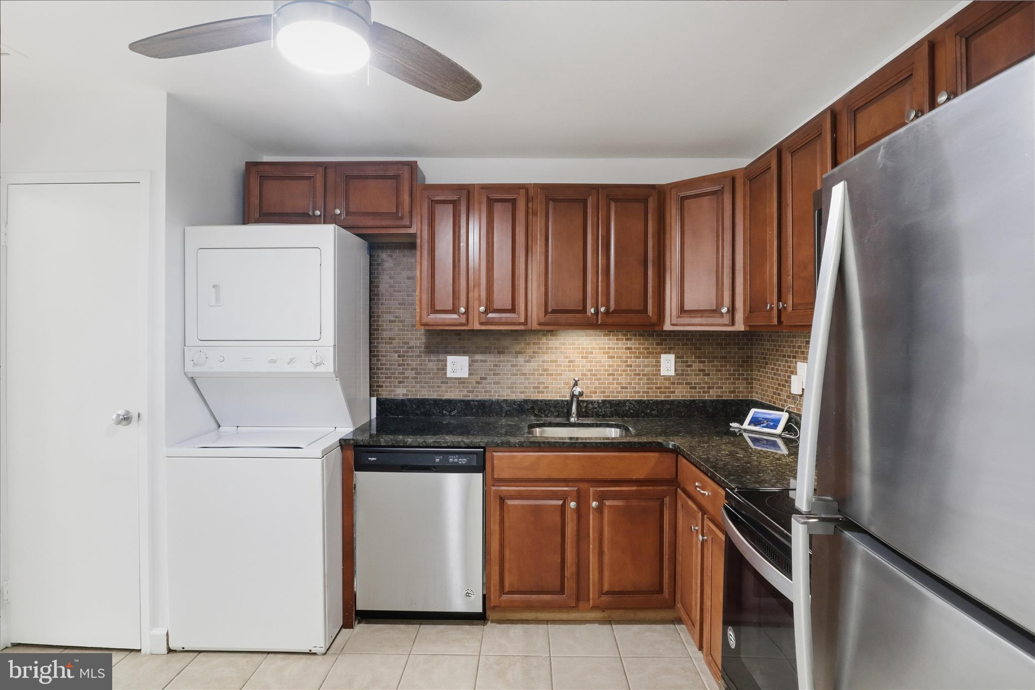 250 South Reynolds Street, Unit 105 Alexandria, VA 22304 - Photo 13 of 39 a kitchen with stainless steel appliances granite countertop a refrigerator sink and stove