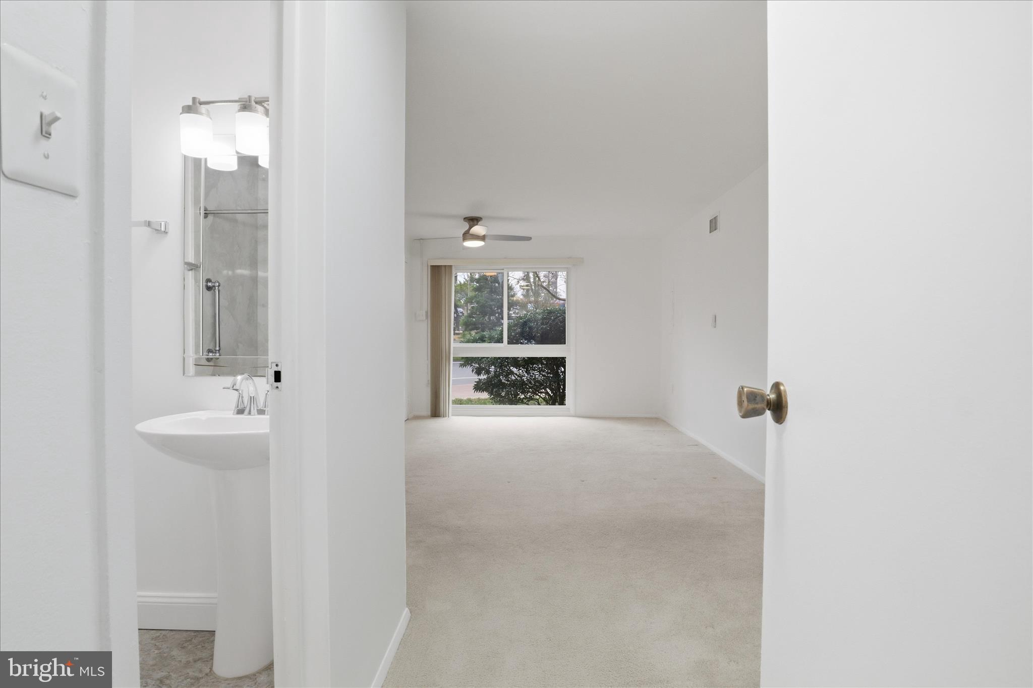 250 South Reynolds Street, Unit 105 Alexandria, VA 22304 - Photo 16 of 39 a bathroom with a tub sink and mirror
