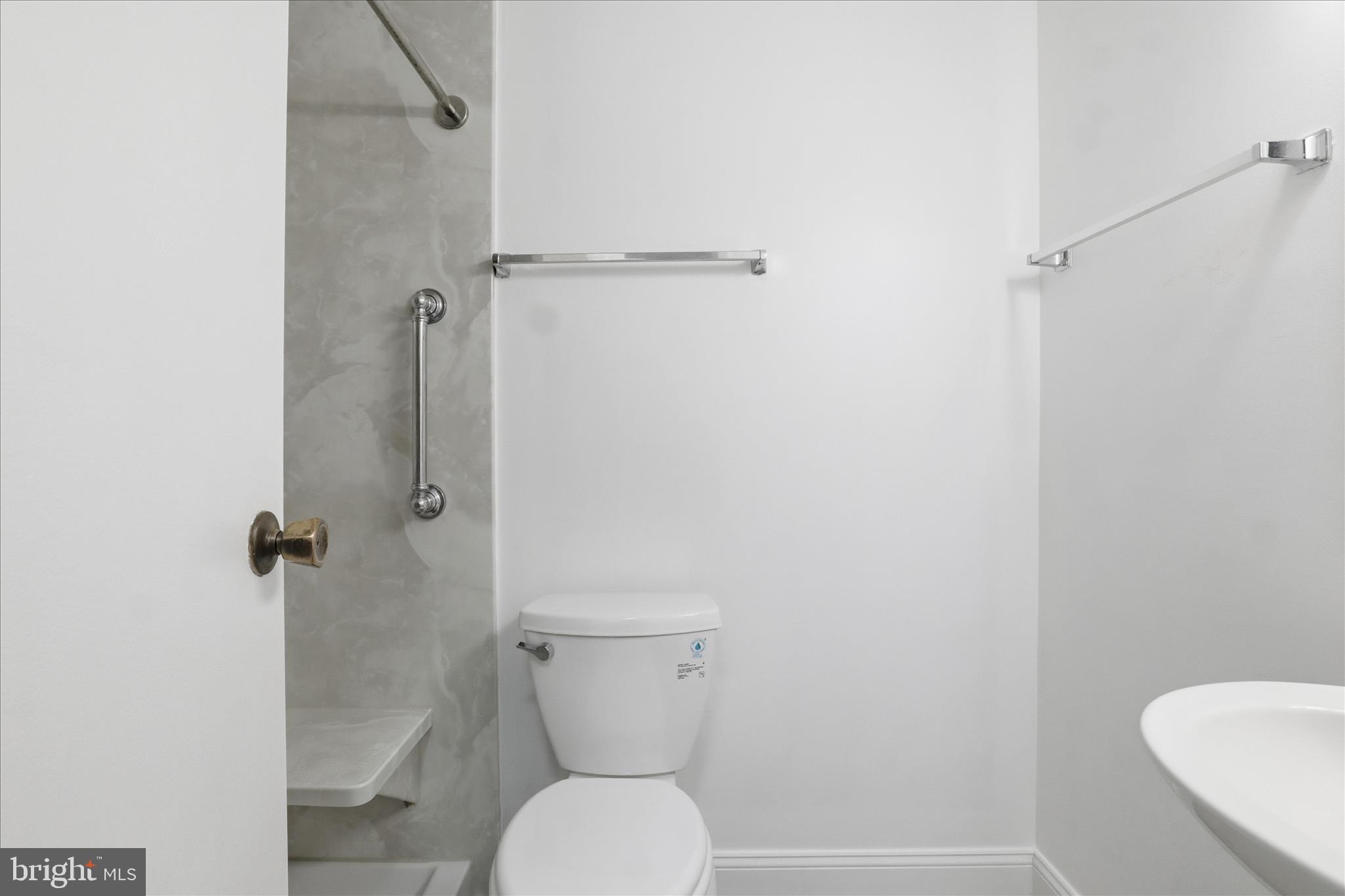 250 South Reynolds Street, Unit 105 Alexandria, VA 22304 - Photo 17 of 39 a white toilet sitting next to a bathroom sink