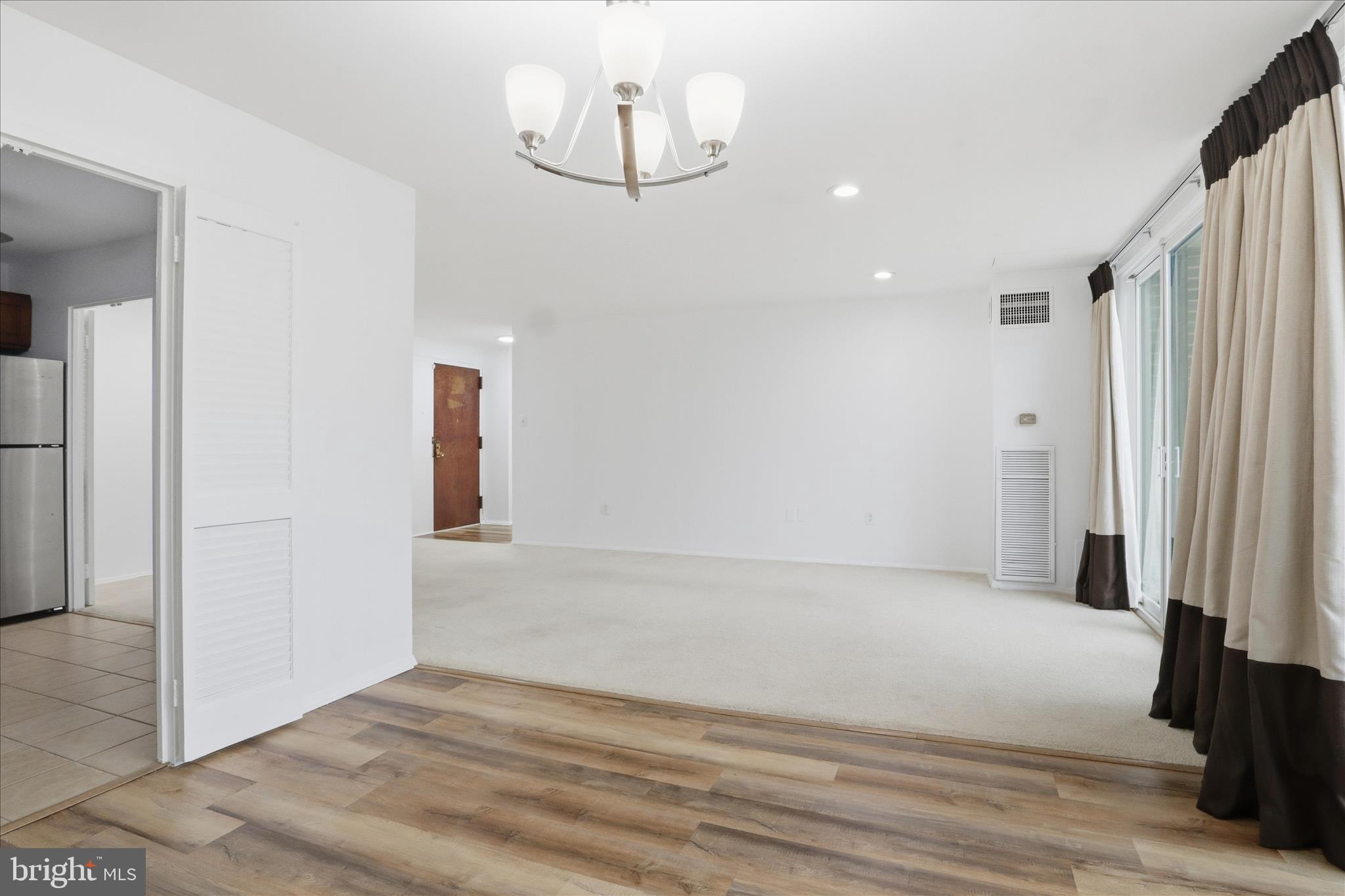 250 South Reynolds Street, Unit 105 Alexandria, VA 22304 - Photo 10 of 39 a view of an empty room with wooden floor and a window