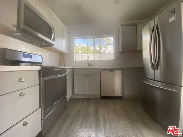 a kitchen with a refrigerator sink and cabinets
