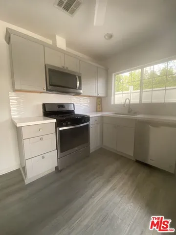 a kitchen with stainless steel appliances a stove a sink and a microwave