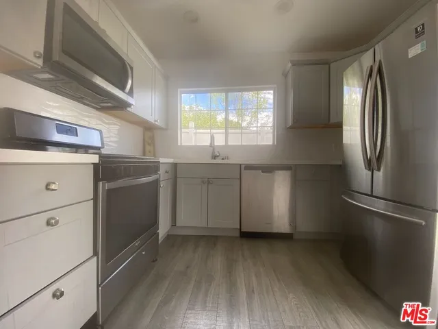a kitchen with a refrigerator sink and cabinets