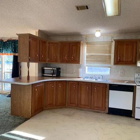 a kitchen with stainless steel appliances granite countertop a sink a stove and a refrigerator