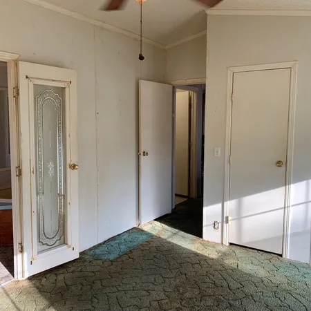 a view of an empty room with closet and a window