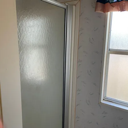 a white toilet sitting next to a shower