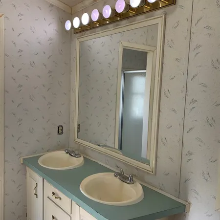 a bathroom with a tub a sink and a mirror
