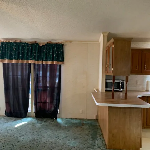 a view of a room with wooden floor and ceiling fan
