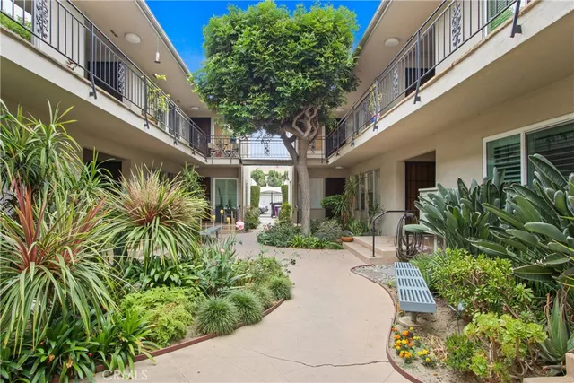 a view of a building with potted plants and a bench