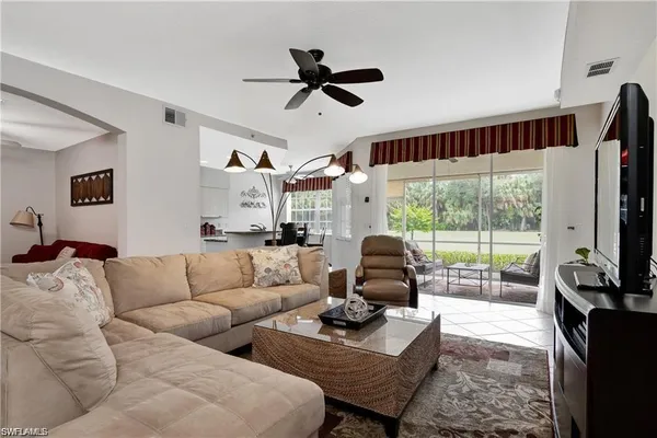 a living room with furniture a flat screen tv and a large window