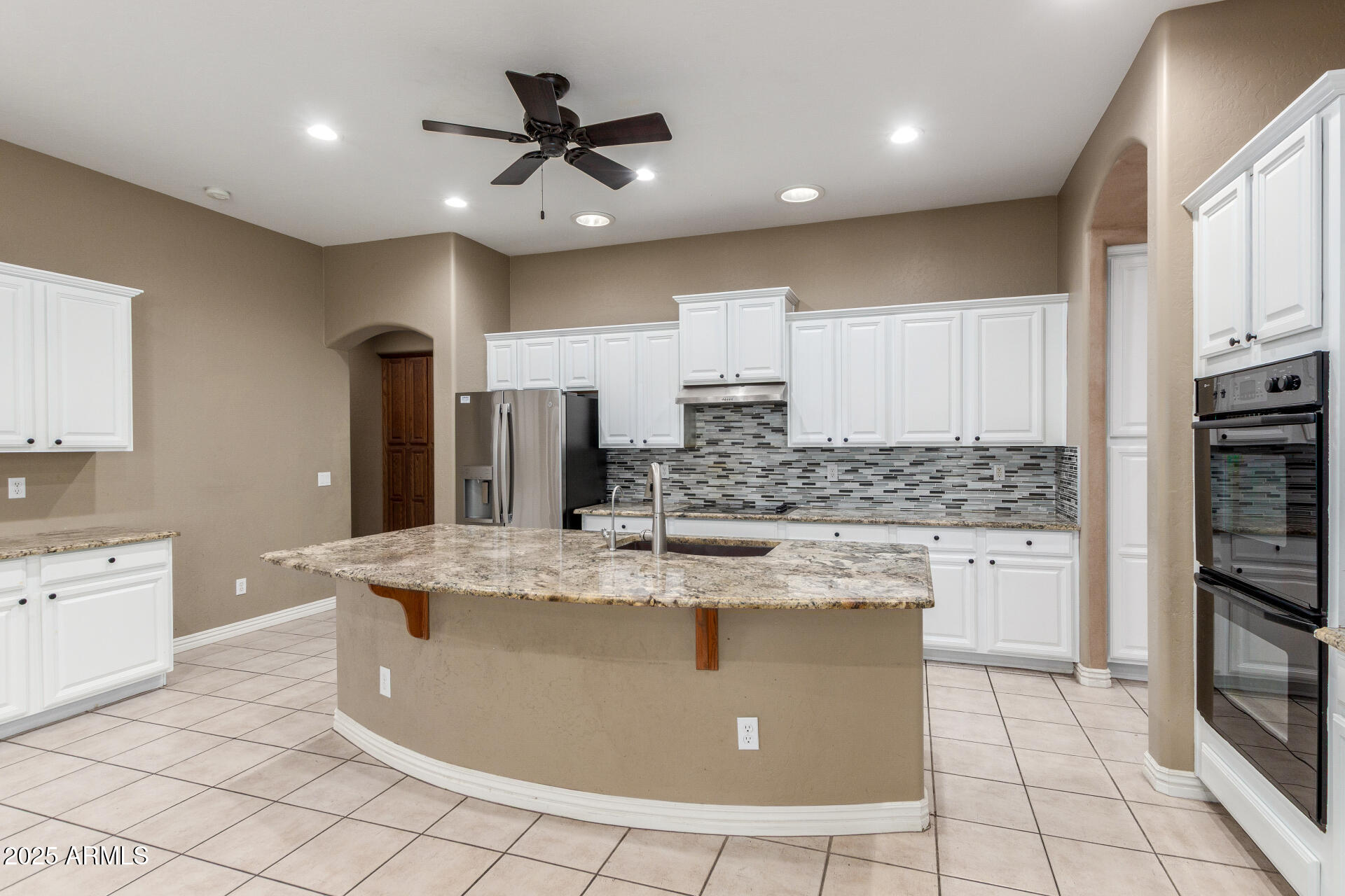 14380 West Monte Vista Road Goodyear, AZ 85395 - Photo 15 of 37 a kitchen with stainless steel appliances granite countertop a sink a stove a refrigerator cabinets and chairs