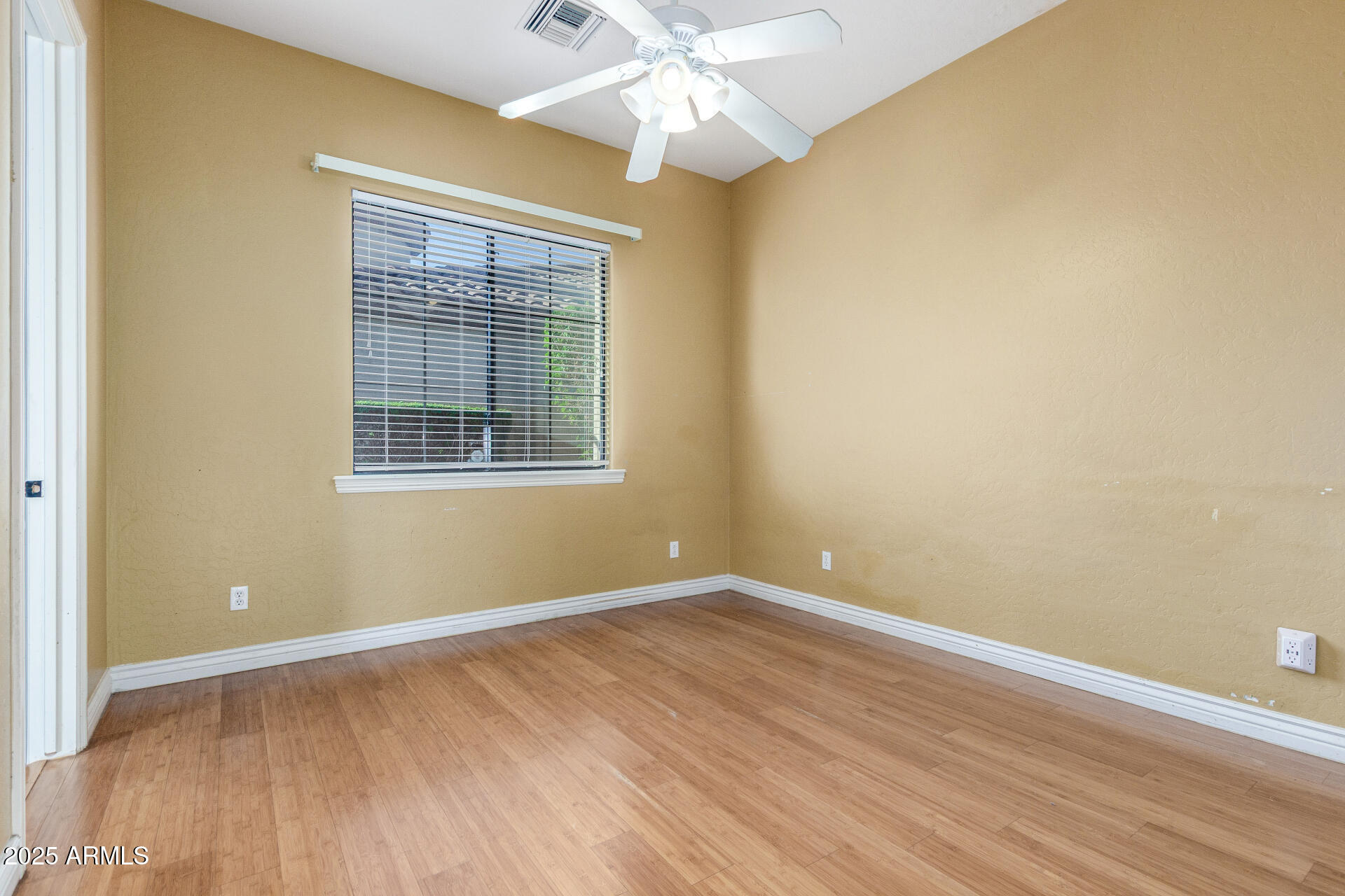 14380 West Monte Vista Road Goodyear, AZ 85395 - Photo 24 of 37 a view of empty room with wooden floor and fan