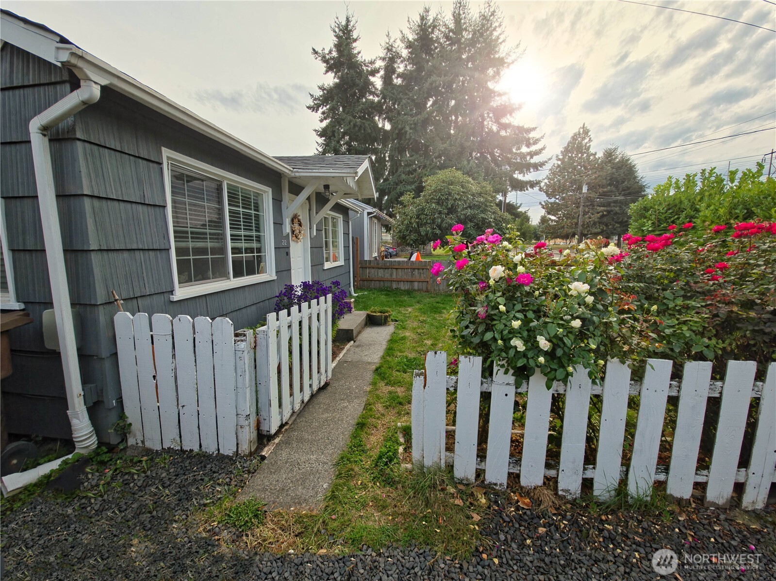 212 Douglas Street Longview, WA 98632 - Photo 4 of 20 a view of a house with wooden fence and flowers