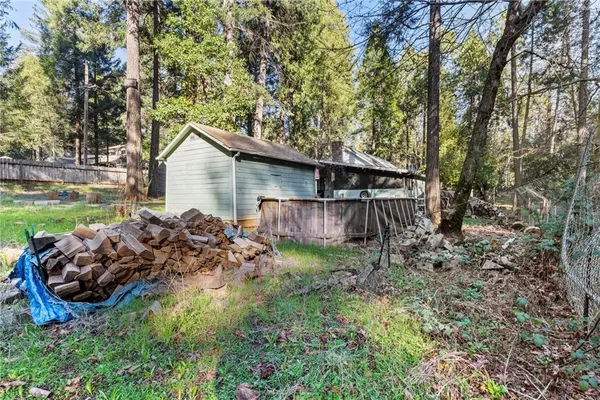 a view of a house with a yard and large trees