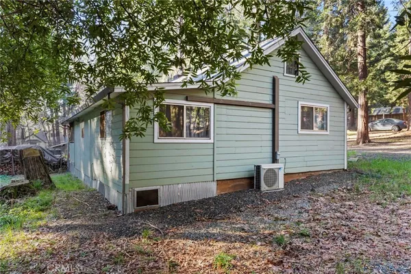a view of a house with backyard and a tree