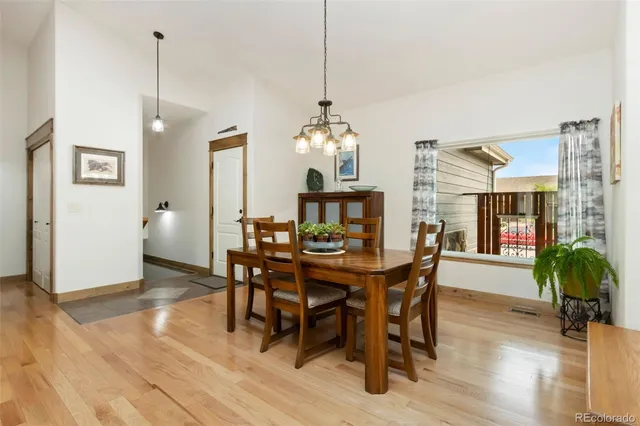 a view of a dining room and livingroom with furniture wooden floor a chandelier