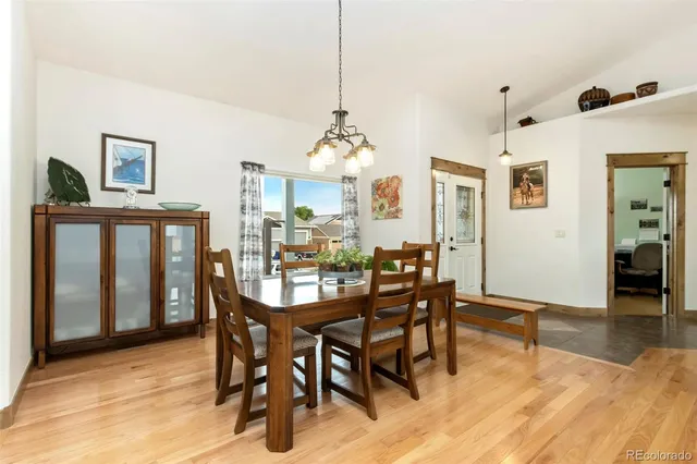 a kitchen with stainless steel appliances kitchen island granite countertop a stove a sink a refrigerator a dining table and chairs