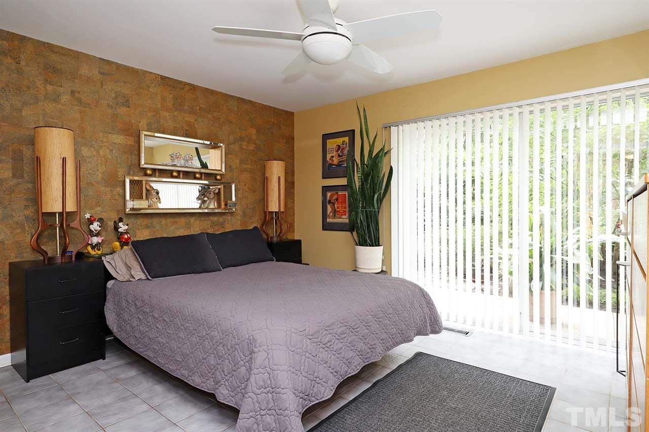4613 Oak Park Road Raleigh, NC 27612 - Photo 9 of 25 a bedroom with a large bed and a chandelier