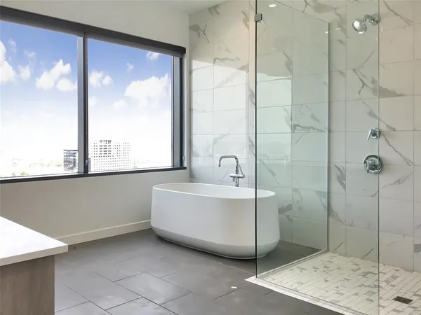 a bathroom with a bathtub and next to a window