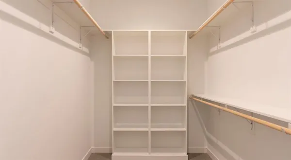 a view of walk in closet with empty racks