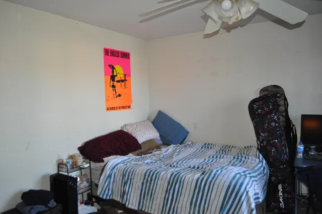 a bedroom with a bed and a chair in it