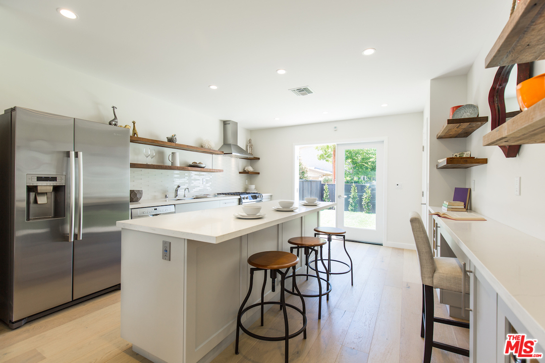 905 Lucille Avenue Venice, CA 90291 - Photo 6 of 24 a kitchen with stainless steel appliances a table chairs refrigerator and microwave