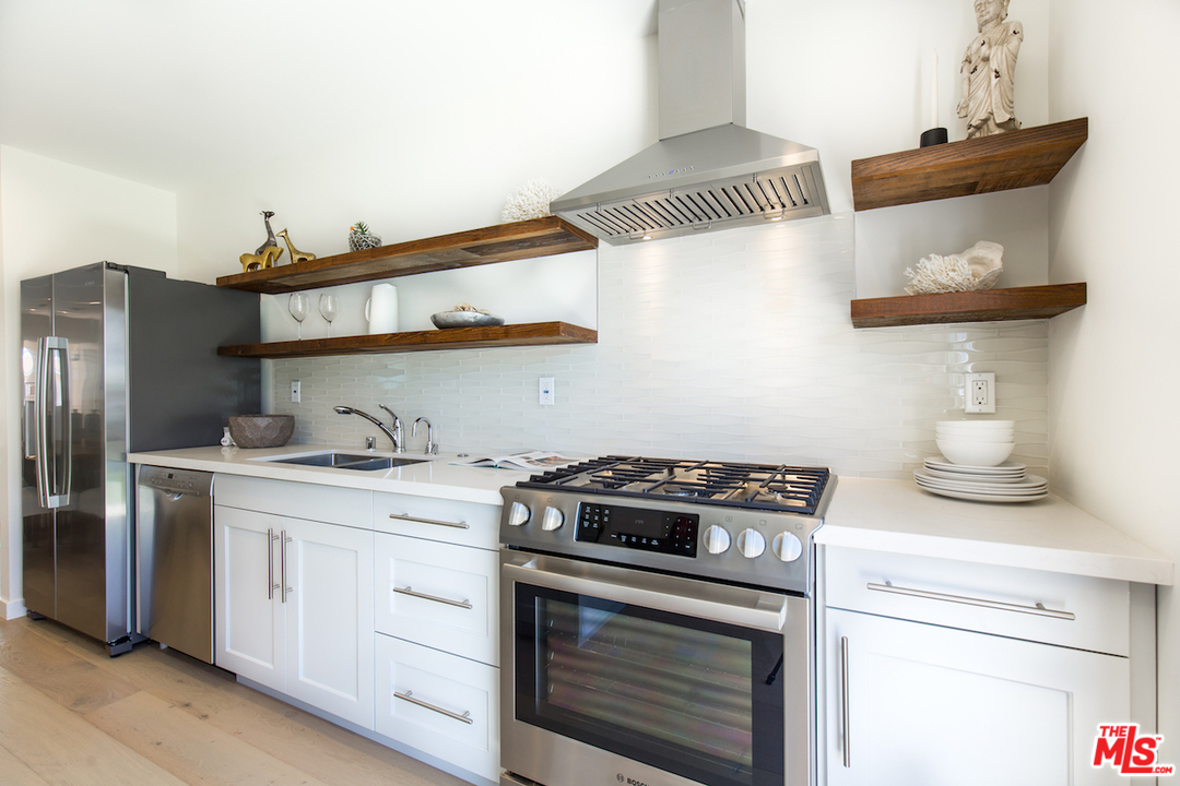 905 Lucille Avenue Venice, CA 90291 - Photo 7 of 24 a kitchen with stainless steel appliances granite countertop a stove and a white cabinets