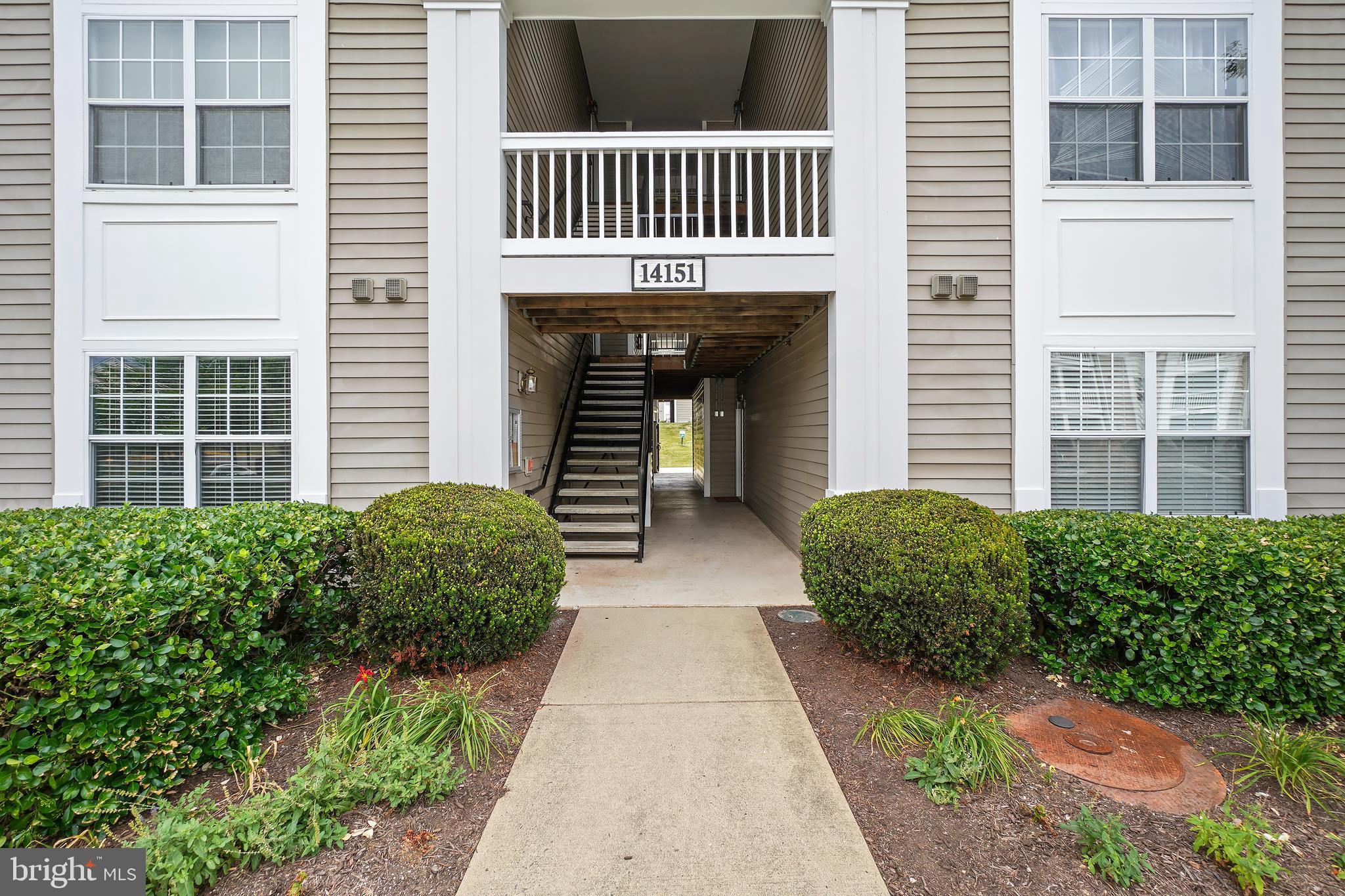 14151 Cuddy Loop, Unit 101 Woodbridge, VA 22193 - Photo 29 of 45 a view of a brick house with large windows and a yard
