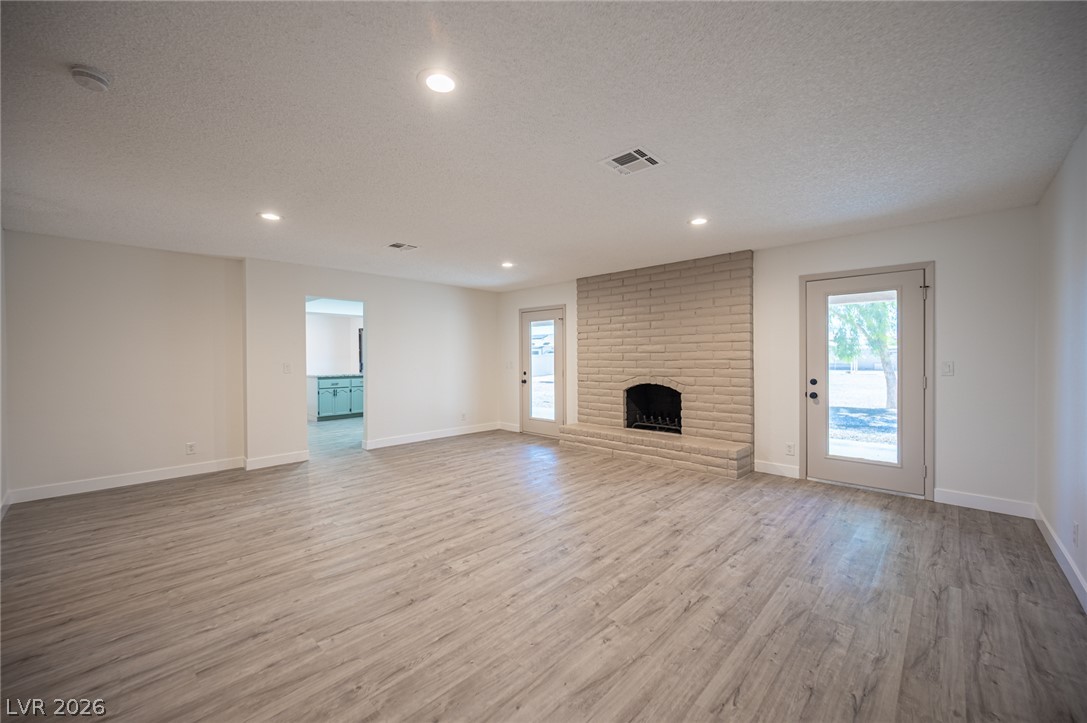 7041 North Decatur Boulevard Las Vegas, NV 89131 - Photo 14 of 33 A spacious living area featuring a neutral brick fireplace and durable wood-look flooring.