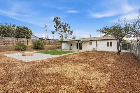 a view of a house with backyard and a tree