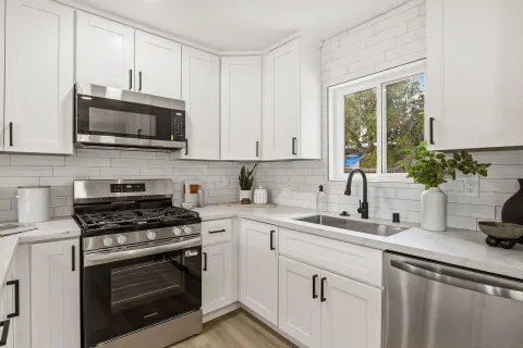 a kitchen with cabinets stainless steel appliances a sink and a microwave