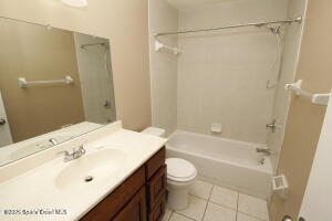 1021 Abada Court Northeast, Unit 102 Palm Bay, FL 32905 - Photo 13 of 16 a bathroom with a sink a toilet and shower