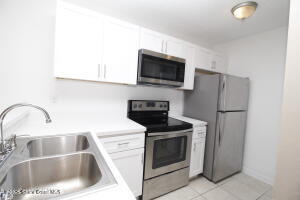 1021 Abada Court Northeast, Unit 102 Palm Bay, FL 32905 - Photo 6 of 16 a kitchen with a sink and steel appliances