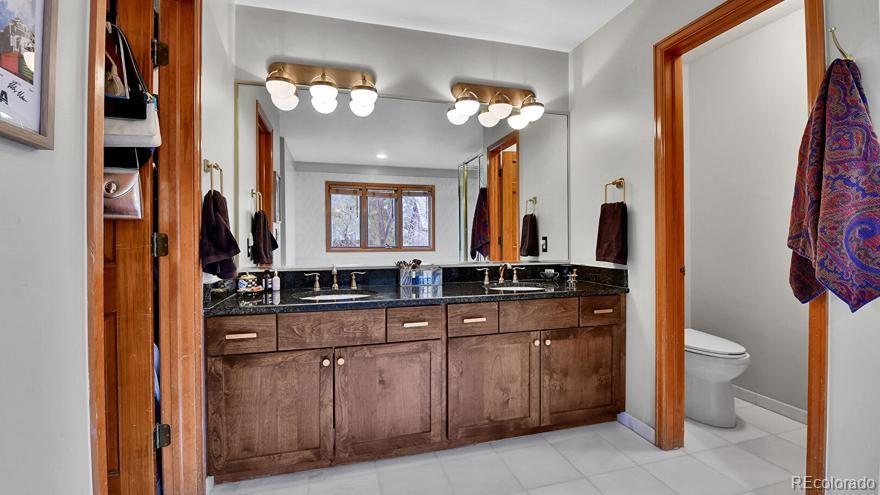 4852 South Carson Street Aurora, CO 80015 - Photo 26 of 48 a bathroom with a toilet sink and mirror