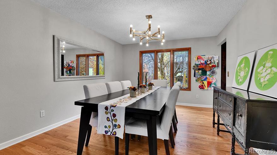 4852 South Carson Street Aurora, CO 80015 - Photo 10 of 48 a view of a dining room with furniture wooden floor and a chandelier
