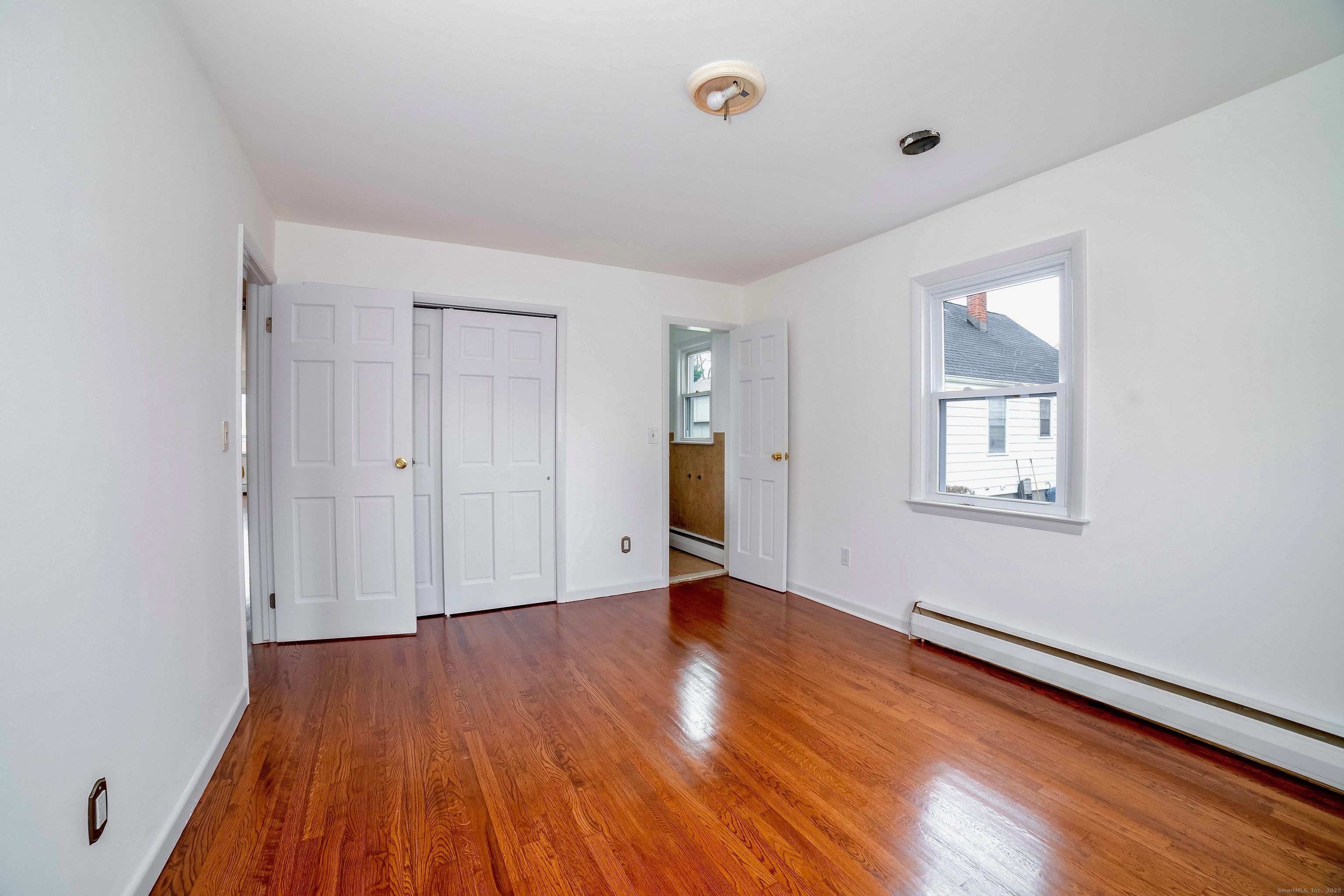 45 Voight Avenue Bridgeport, CT 06606 - Photo 17 of 27 an empty room with wooden floor and windows