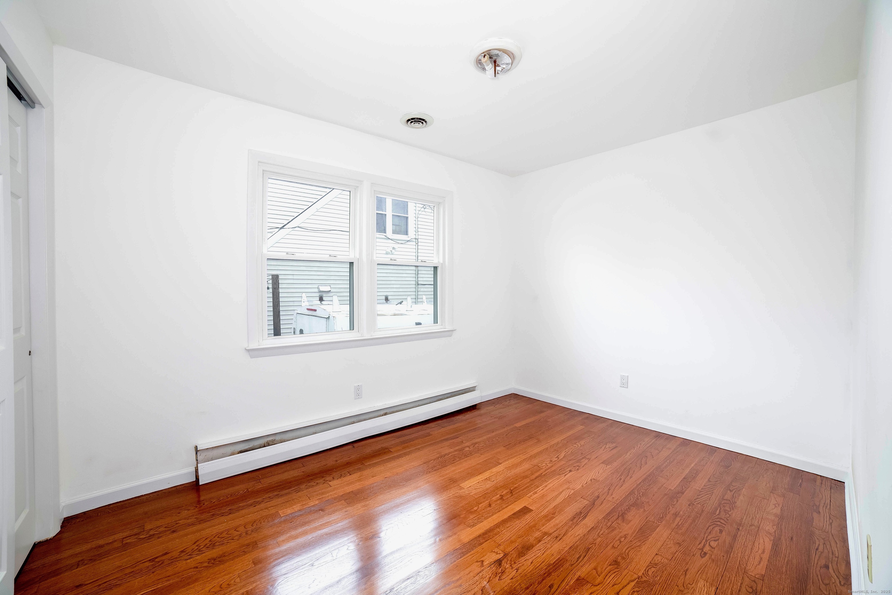 45 Voight Avenue Bridgeport, CT 06606 - Photo 19 of 27 an empty room with wooden floor and windows