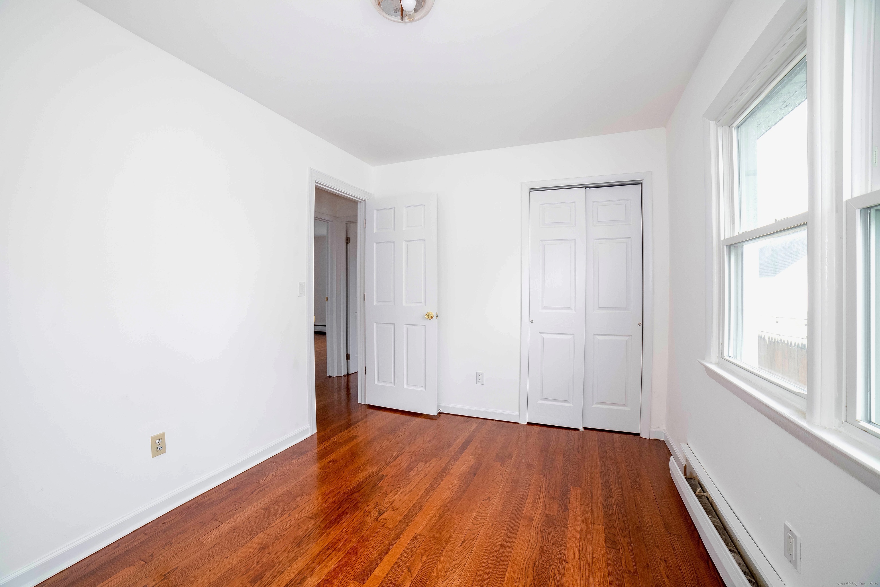 45 Voight Avenue Bridgeport, CT 06606 - Photo 20 of 27 an empty room with wooden floor and windows