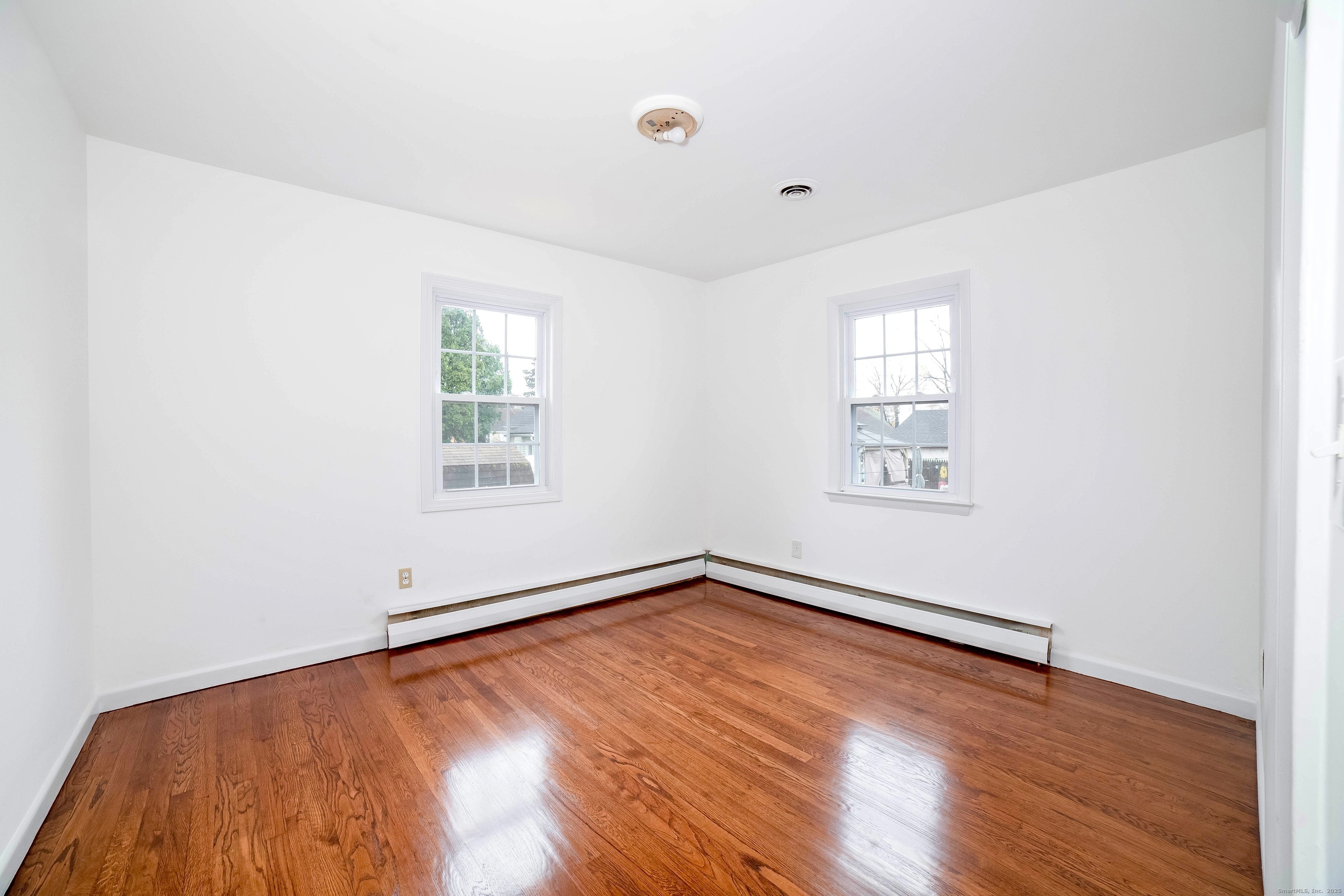 45 Voight Avenue Bridgeport, CT 06606 - Photo 23 of 27 an empty room with wooden floor and windows