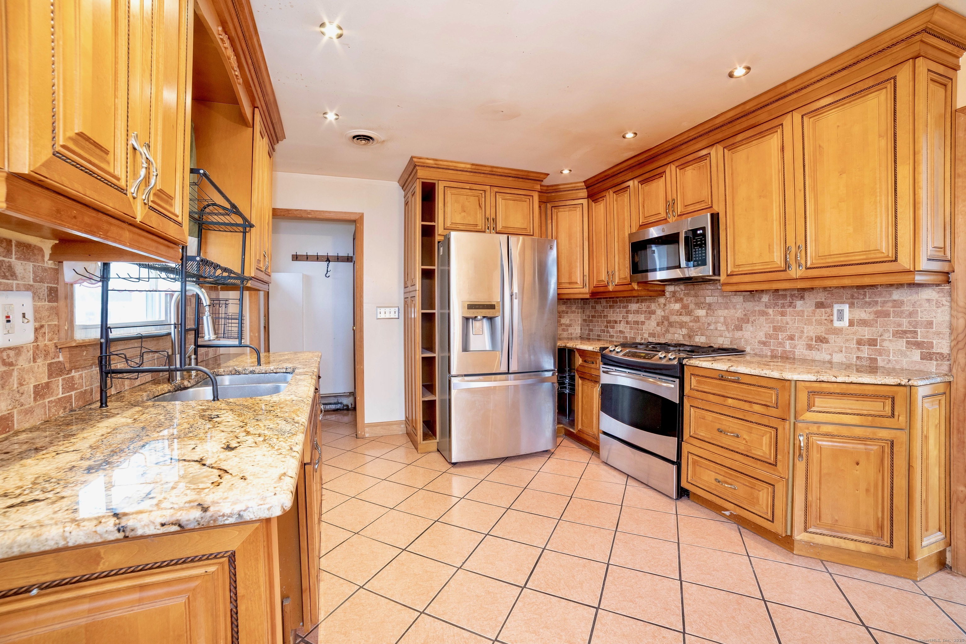 45 Voight Avenue Bridgeport, CT 06606 - Photo 8 of 27 a kitchen with stainless steel appliances granite countertop a stove a sink and a microwave