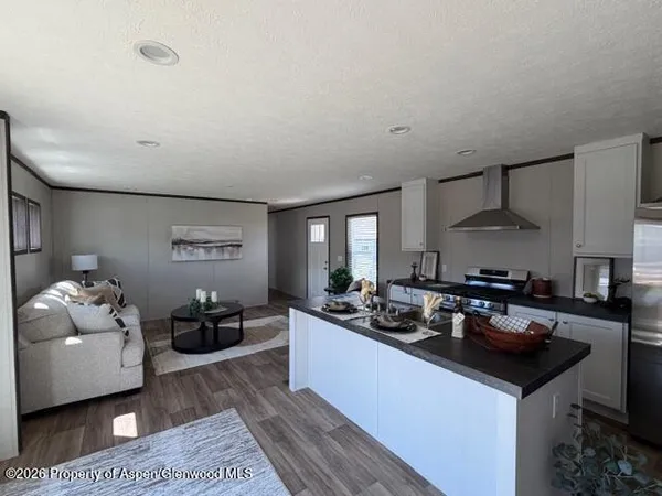 a kitchen with granite countertop a sink dishwasher stove and cabinets