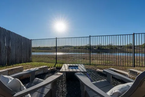a view of roof deck with couches and wooden fence